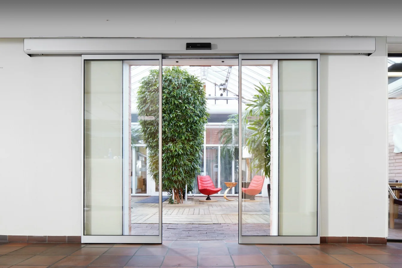 ASSA ABLOY SL500 schuifdeurautomaat boven een glazen entree